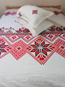 - un lit avec une couette rouge et blanche dans l'établissement Cabana Briana, à Valea Drăganului