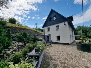 une maison blanche avec un toit noir dans l'établissement Apartamenty Salamandra, à Kłodzko