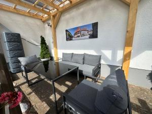 a patio with a couch and a table and a building at Ferienwohnung an der Thyrahöhe in Stolberg