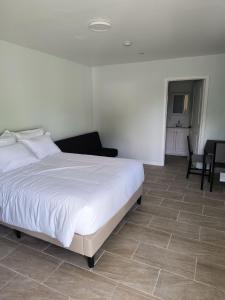 una camera con letto bianco e pavimento piastrellato di Islander Motel 