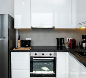 a kitchen with white cabinets and an oven in it at Olvia A breath away from Old Town Center in Rethymno
