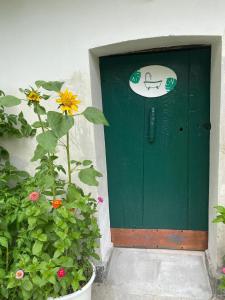 una porta verde con un cartello per cani di La Dimora delle Viole a Lauriano