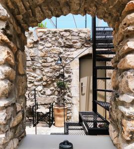- un bâtiment en pierre avec un mur en pierre et un escalier dans l'établissement Pyrgi Cretan Living & Spa, à Pírgos