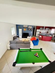 a living room with a pool table and a couch at La maison dans les noyer in Sainte-Eulalie