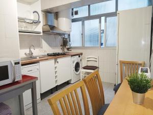 a kitchen with a table and a stove top oven at Habitaciones en Apartamento compartido DELICIAS ROOM Cerca del Mar, Aeropuerto, Ave y Metro in Málaga