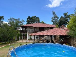 uma casa com piscina em frente a uma casa em Villa Higueras em Barichara
