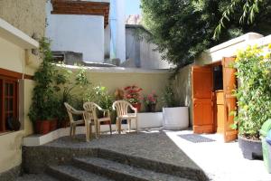 une terrasse avec 2 chaises, une table et des plantes dans l'établissement Karma Lodge, à Leh