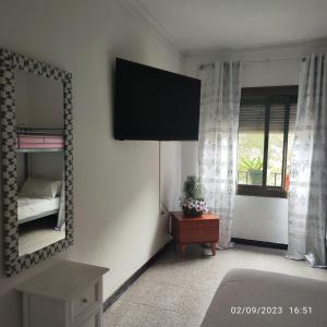 una camera da letto con specchio, letto e finestra di Apto Barcelona C R a Santa Coloma de Gramanet