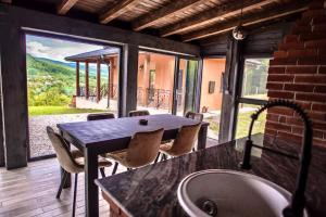a kitchen with a table and chairs and a large window at Cabana lui Matei in Coasta