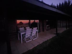 einen Tisch und Stühle auf einer Terrasse in der Nacht in der Unterkunft 9 Stoney Way Cottage in Underberg