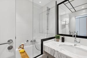 ein weißes Bad mit einem Waschbecken und einer Dusche in der Unterkunft Home and CoLiving Bonn I Aparthotel I Soft Opening in Bonn