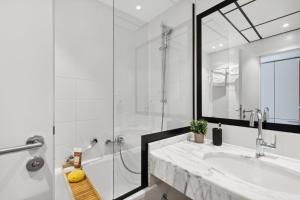 a white bathroom with a sink and a shower at Home and CoLiving Bonn I Aparthotel in Bonn +46 photos