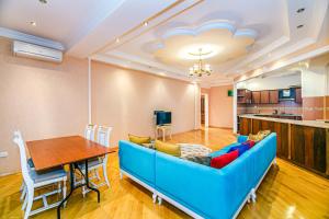 a living room with a blue couch and a table at Deluxe Apartment 142/43 in Baku