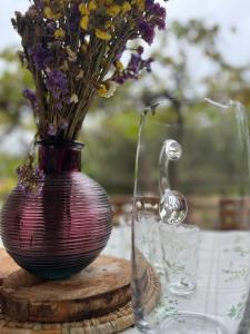 un jarrón púrpura con flores en una mesa en Apartman Mišo en Okrug Donji