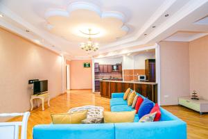 a living room with a blue couch and a kitchen at Deluxe Apartment 142/43 in Baku