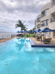 a large blue swimming pool next to a building at Modern 2Bedroom Self Catering unit HBos. in Mossel Bay