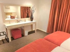 a hotel room with a sink and a mirror at Modern 2Bedroom Self Catering unit HBos. in Mossel Bay