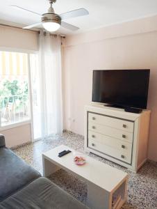 a living room with a couch and a flat screen tv at Habitaciones en Apartamento compartido DELICIAS ROOM Cerca del Mar, Aeropuerto, Ave y Metro in Málaga