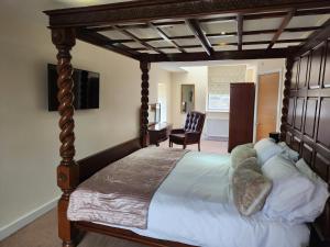 a bedroom with a large bed with a wooden canopy at The Garden Bar Rooms in Baildon