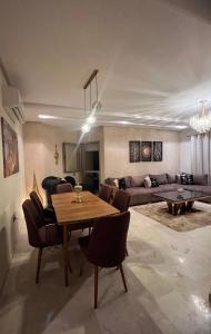 sala de estar con mesa y sofá en Prestigia golf city porte agate, en Marrakech