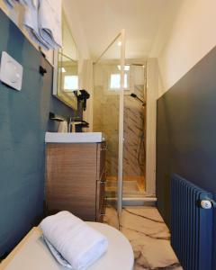 a bathroom with a shower and a toilet and a sink at Hôtel du Golfe Sete-Balaruc in Balaruc-les-Bains