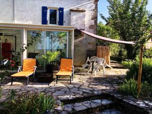 a patio with chairs and a table in a yard at Le Gîte des Cimes in Tulle