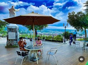 Villa anugerah hill في Tomohon: يجلس شخصان على طاولة تحت مظلة
