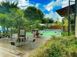 - une terrasse avec des chaises et des tables sur un court de tennis dans l'établissement Villa anugerah hill, à Tomohon