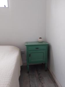 a green nightstand next to a bed in a room at Aires de mar in San Clemente del Tuyú