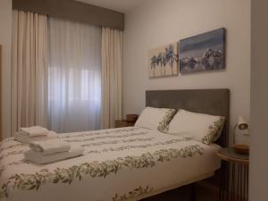 a bedroom with a bed with towels on it at NUEVO-LUMINOSO Y MODERNO. Parking gratis!! in Seville