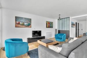 sala de estar con sofá y sillas azules en Les Pieds dans l'Eau, en Tresserves