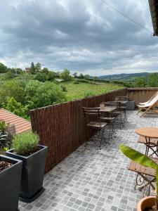 a patio with tables and chairs and a fence at Maison sur cour et véranda in Courzieu