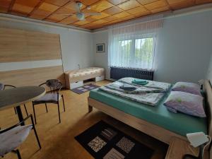 1 dormitorio con 1 cama, mesa y sillas en Gemütliche Ferienwohnung in Körba am See 