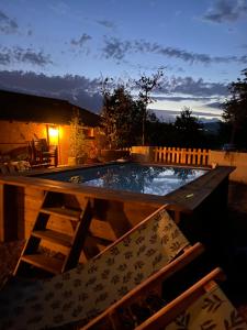 a swimming pool in the middle of a backyard at night at Maison sur cour et véranda in Courzieu