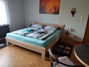 een slaapkamer met een bed, een tafel en een stoel bij Gemütliche Ferienwohnung in Körba am See 