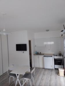 a kitchen with a table and chairs in a room at Aires de mar in San Clemente del Tuyú