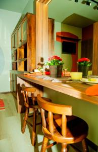 a kitchen with a counter with four chairs at a bar at HOSPEDAGEM CASA COMPACTA in Jaraguá do Sul