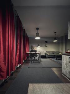 salon z czerwonymi zasłonami i stołem w obiekcie Apartament Na Chłodnej | The High Street w mieście Suwałki