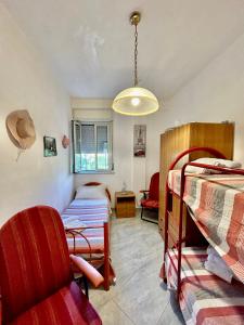 sypialnia z dwoma łóżkami piętrowymi i krzesłem w obiekcie Aromi di Sicilia Casa Vacanze w mieście Palermo