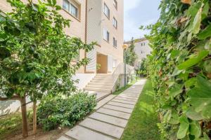 una passerella di fronte a un edificio con piante di Apartamento en complejo residencial, con piscina. a Salou