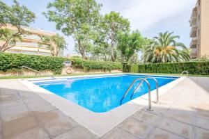 a swimming pool in front of a building at Apartamento en complejo residencial, con piscina. in Salou