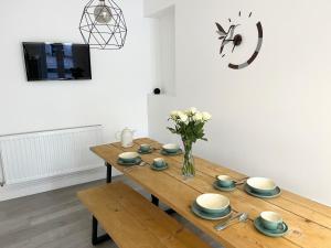 a dining room table with a vase of flowers on it at Saltwater Pearl - A charming 4 bed townhouse in Ilfracombe