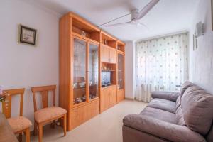 a living room with a couch and a tv at Apartamento en complejo residencial, con piscina. in Salou