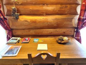 a wooden table in front of a wooden wall at Buckey Lodge, à 2 minutes des cascades de Tendon in Tendon