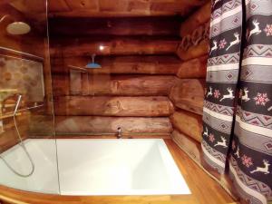 a bath tub in a room with wooden walls at Buckey Lodge, à 2 minutes des cascades de Tendon in Tendon