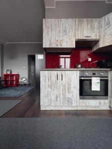 a kitchen with red walls and wooden cabinets at Apartament Na Chłodnej | The High Street in Suwałki