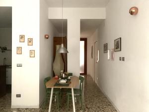 a dining room with a table and green chairs at Il Giardino Segreto in Parma
