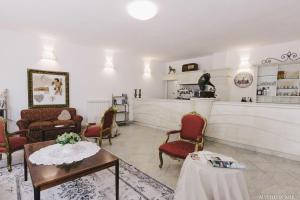 un soggiorno con sedie, tavolo e bancone di Hotel - Ristorante Pintadera a Massa