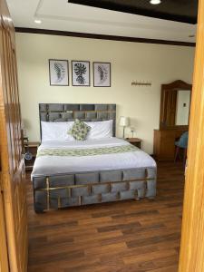 een slaapkamer met een groot bed met witte lakens bij Umda Hotel Galaxy in Nathia Gali