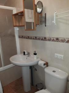 a bathroom with a white sink and a toilet at Luna Menguante in Robledillo de Gata +26 photos